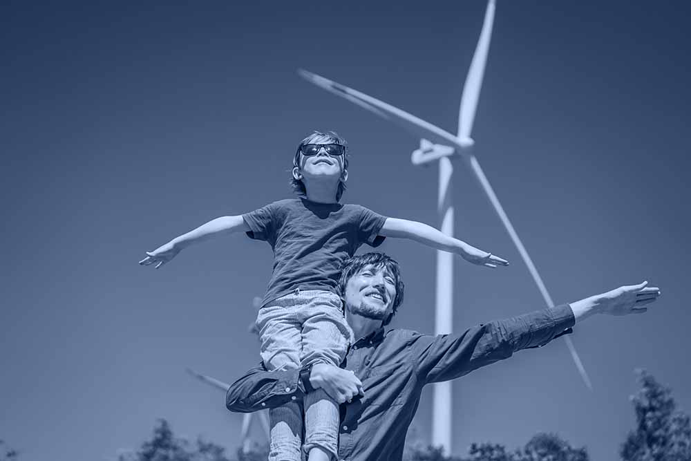 father and son next to a wind mill